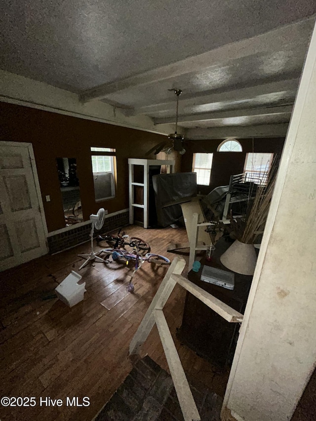 interior space with hardwood / wood-style flooring, ceiling fan, and beam ceiling