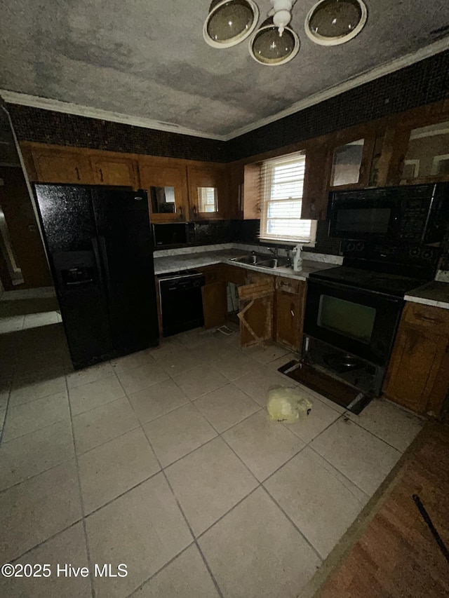 kitchen featuring light tile patterned floors, sink, crown molding, and black appliances