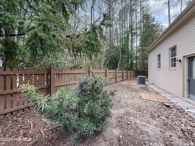 view of yard featuring fence and central air condition unit