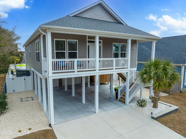 coastal home featuring a porch and a carport