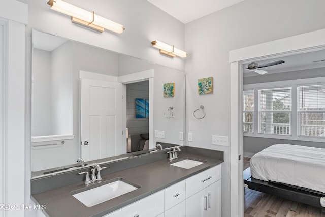 106 SE 36th St, Oak Island, NC 28465 - full bathroom with ensuite bath, double vanity, wood finished floors, and ceiling fan