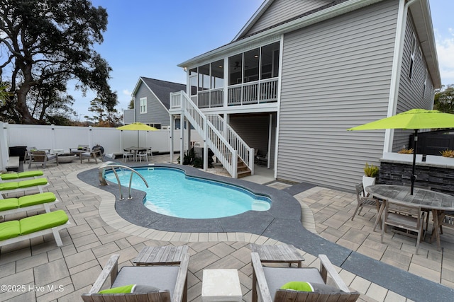 view of swimming pool with a patio area and a sunroom