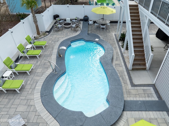 view of swimming pool with a fire pit and a patio area