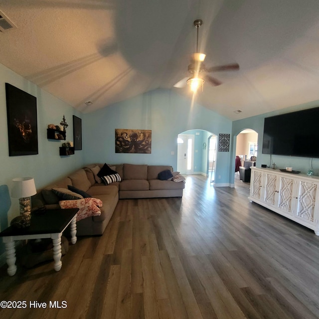 living room with ceiling fan, dark hardwood / wood-style floors, and vaulted ceiling