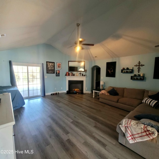 living room with hardwood / wood-style flooring, vaulted ceiling, and ceiling fan