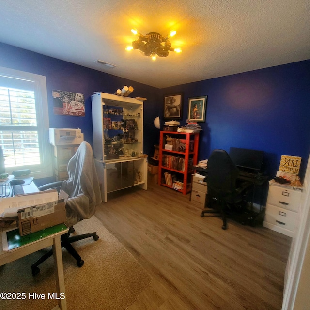 office space with an inviting chandelier, hardwood / wood-style flooring, and a textured ceiling