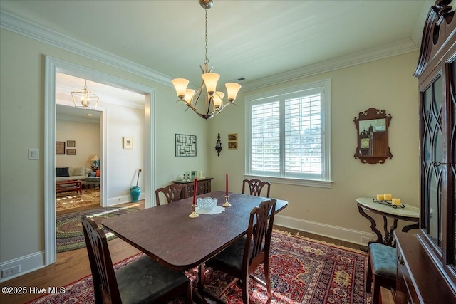 dining area with baseboards, a notable chandelier, wood finished floors, and ornamental molding