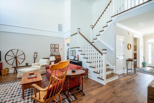 interior space featuring visible vents, stairway, crown molding, and wood finished floors