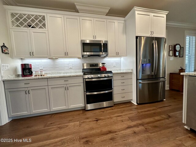 kitchen with decorative backsplash, appliances with stainless steel finishes, white cabinets, and a toaster