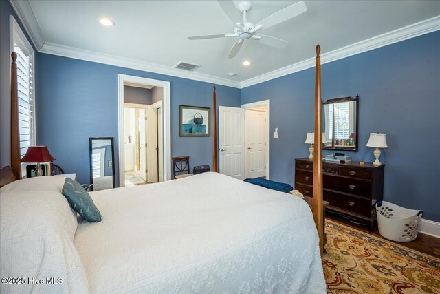 bedroom featuring a ceiling fan, wood finished floors, visible vents, and ornamental molding