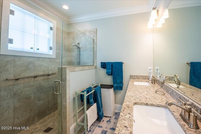 full bath featuring a sink, double vanity, ornamental molding, and a shower stall