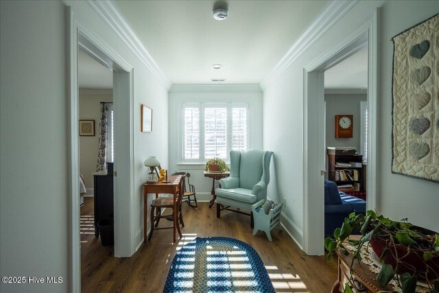 living area with crown molding, wood finished floors, and baseboards