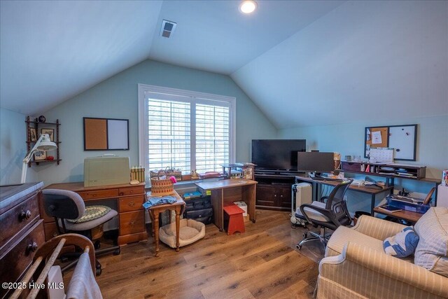 office with vaulted ceiling, wood finished floors, and visible vents