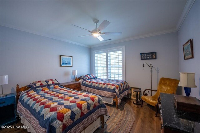 bedroom with crown molding, wood finished floors, visible vents, and ceiling fan