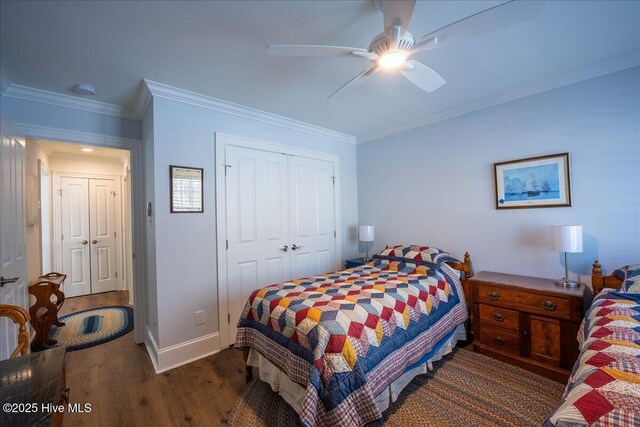 bedroom featuring a closet, wood finished floors, baseboards, and ornamental molding