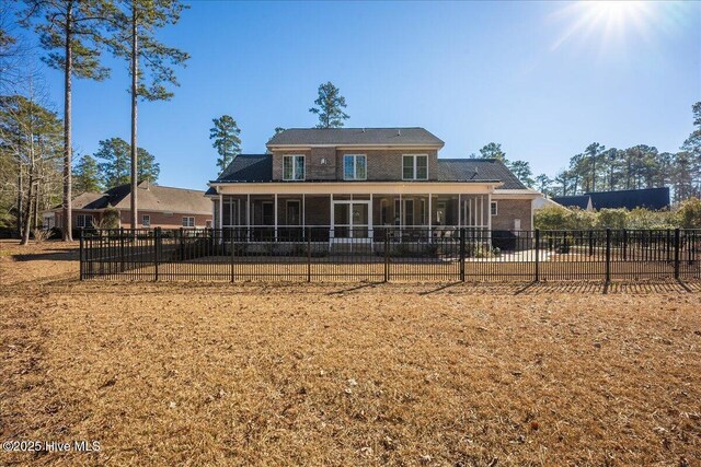 rear view of house with fence private yard and a sunroom