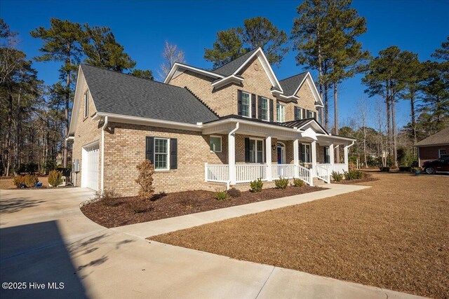 view of front of home featuring brick siding, a porch, roof with shingles, a garage, and driveway