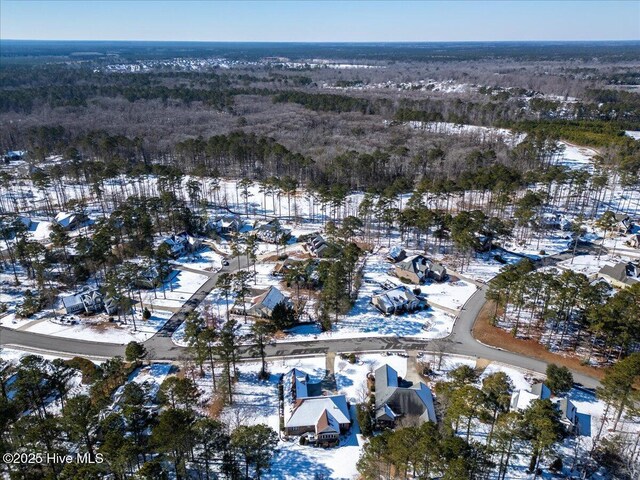 snowy aerial view featuring a forest view