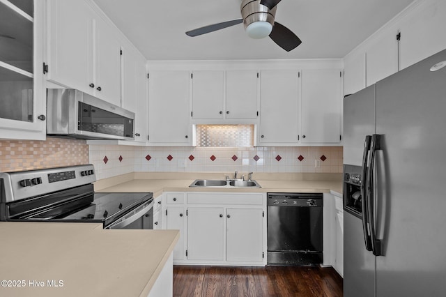 kitchen featuring appliances with stainless steel finishes, tasteful backsplash, white cabinetry, and sink