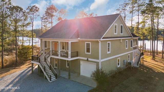 rear view of property with a garage and a water view