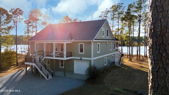 rear view of house with a garage and a water view