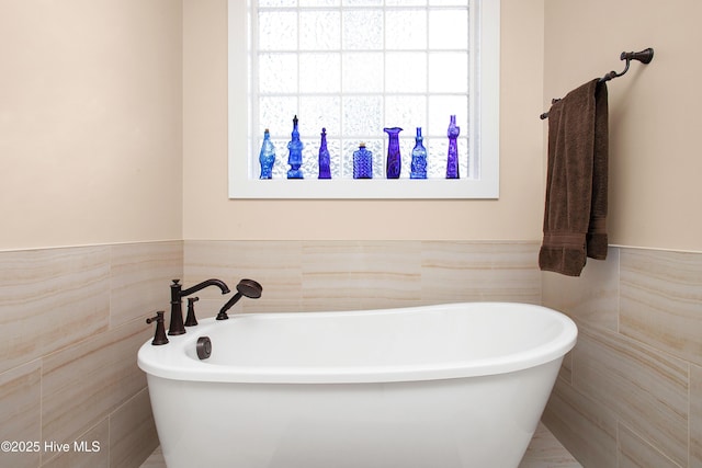 bathroom with tile walls and a bathtub