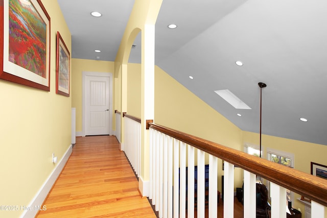 hallway featuring light hardwood / wood-style flooring and lofted ceiling