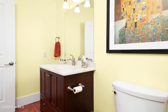 bathroom with toilet, vanity, and tile patterned flooring