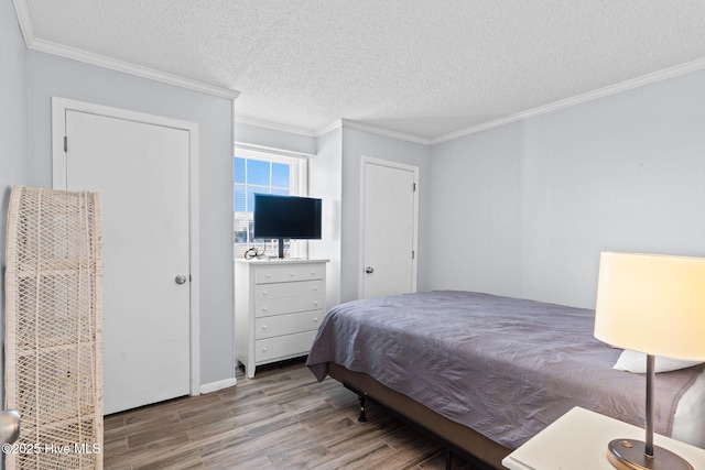 bedroom with ornamental molding, a textured ceiling, and hardwood / wood-style flooring