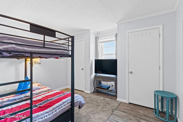 bedroom featuring a textured ceiling, hardwood / wood-style flooring, a closet, and crown molding