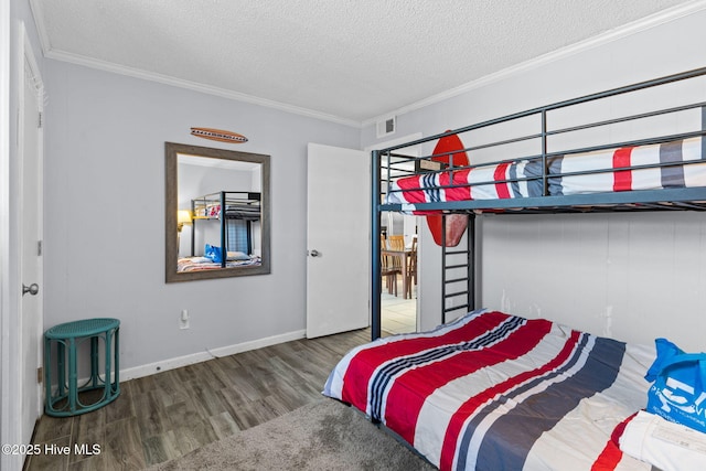 bedroom featuring crown molding, dark hardwood / wood-style floors, and a textured ceiling