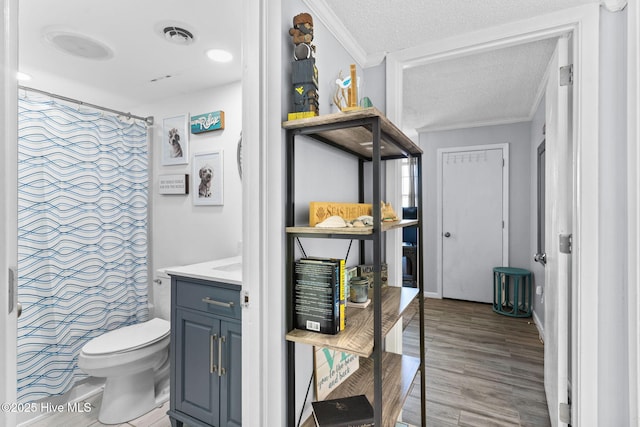 bathroom featuring a shower with curtain, a textured ceiling, vanity, wood-type flooring, and toilet