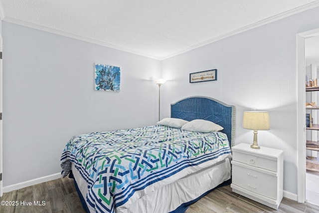 bedroom with crown molding, hardwood / wood-style floors, and a textured ceiling