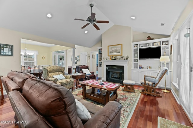 living room with lofted ceiling, ceiling fan with notable chandelier, and wood-type flooring