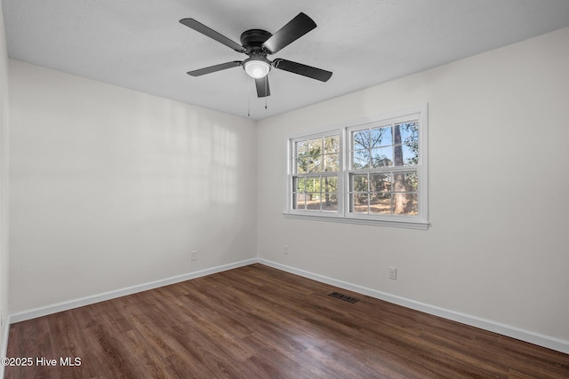 empty room featuring ceiling fan and dark wood-type flooring