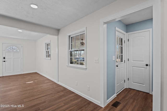 entryway with a textured ceiling and dark wood-type flooring