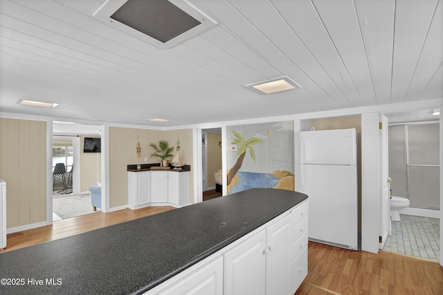 kitchen featuring white fridge, white cabinetry, light hardwood / wood-style floors, and wood ceiling