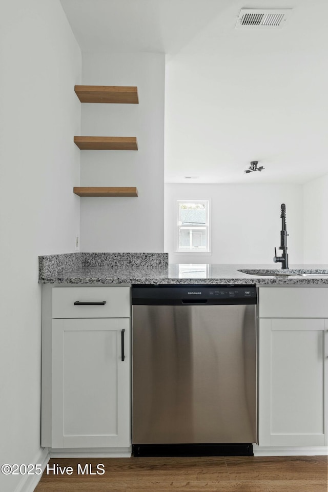 kitchen with dishwasher, white cabinets, light stone countertops, and sink