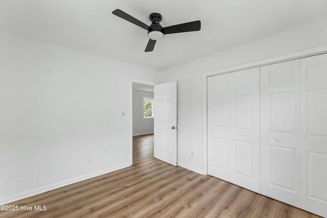 unfurnished bedroom featuring ceiling fan, a closet, and light hardwood / wood-style floors