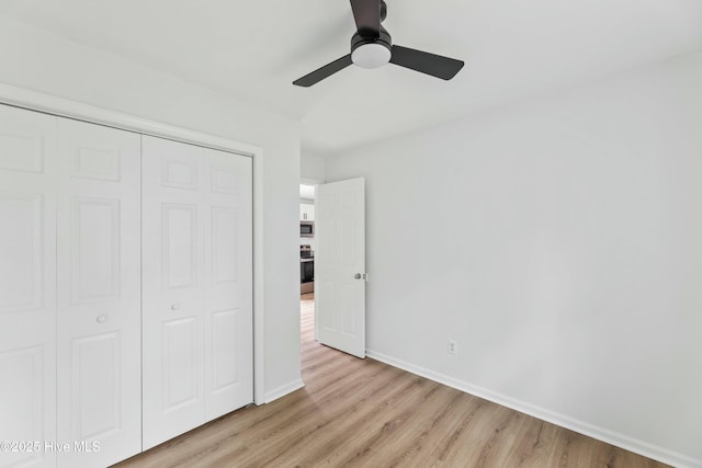 unfurnished bedroom with a closet, light hardwood / wood-style flooring, and ceiling fan