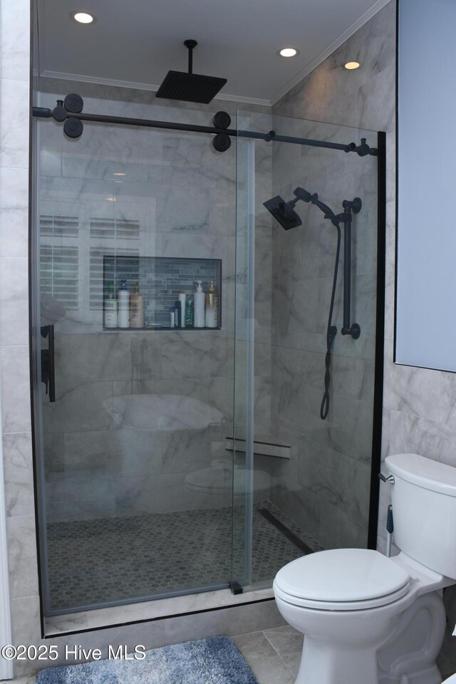 bathroom featuring tile patterned flooring, tile walls, toilet, walk in shower, and crown molding