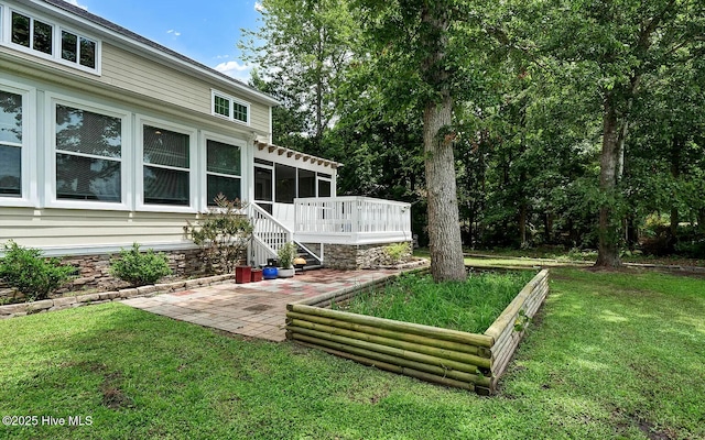 view of yard featuring a wooden deck, a patio area, and a sunroom