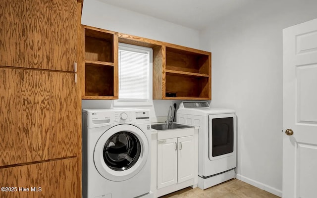 laundry area with sink, light tile patterned floors, cabinets, and washer and dryer