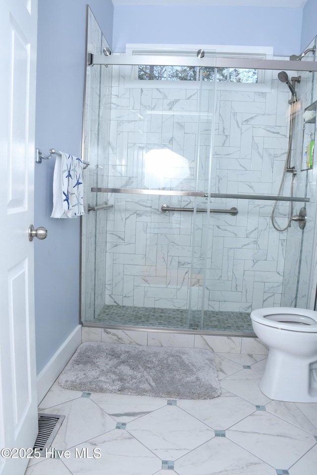 bathroom with toilet and a shower with shower door