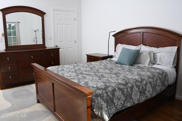 bedroom with dark wood-type flooring