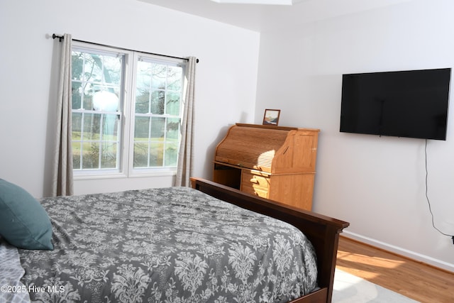 bedroom with multiple windows and wood-type flooring