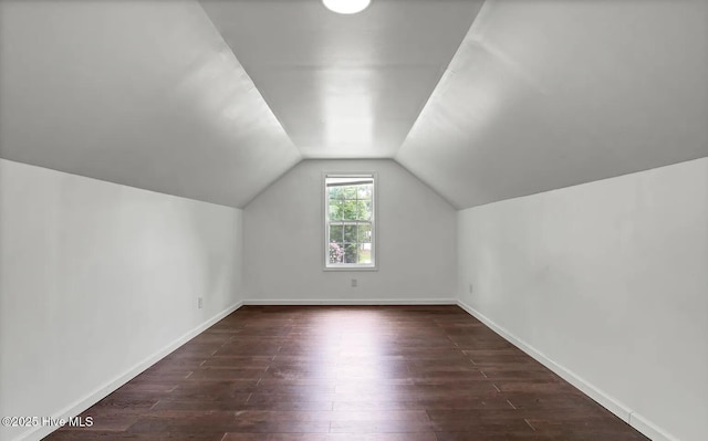 additional living space featuring dark hardwood / wood-style floors and vaulted ceiling