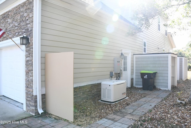 view of side of property featuring a garage and a storage shed