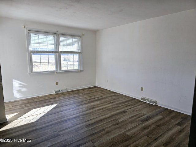 empty room with dark hardwood / wood-style flooring