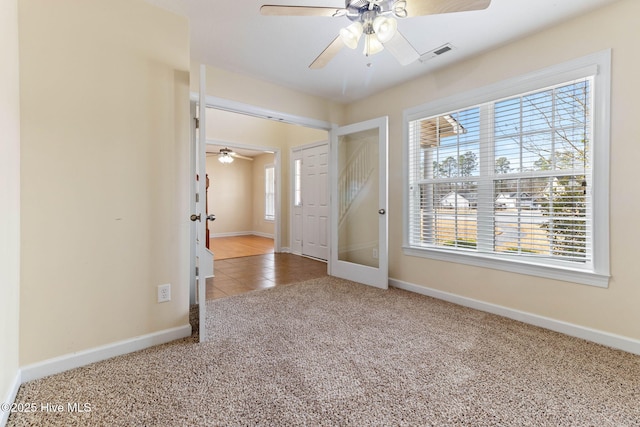 foyer entrance featuring carpet flooring and ceiling fan